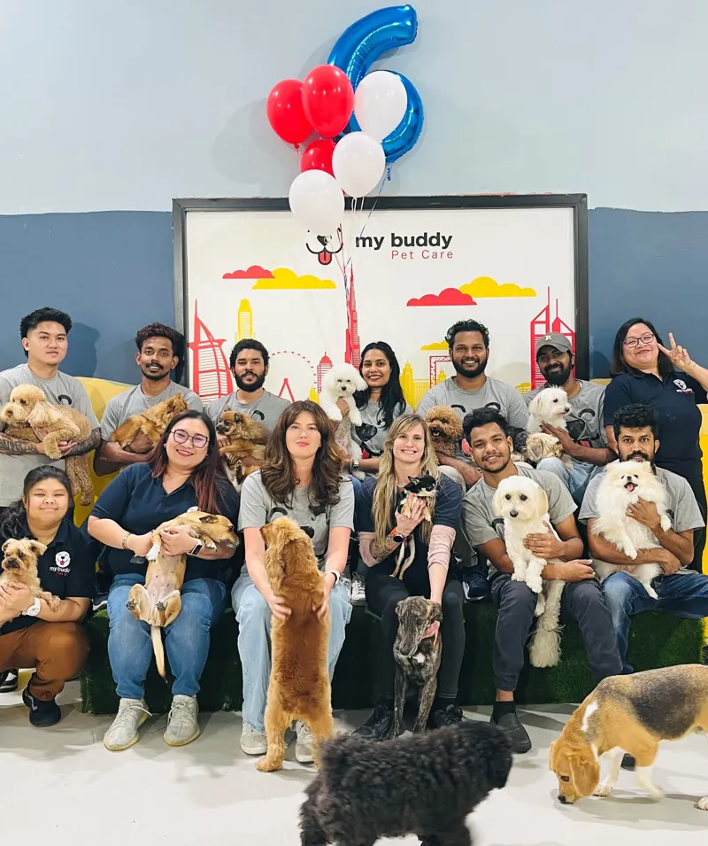 The My Buddy Pet Care team with dogs at a celebration